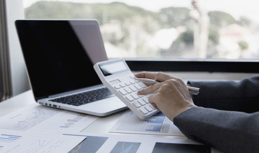 asesor financiero con su calculadora y laptop